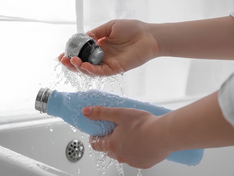 Rửa bình giữ nhiệt mới bằng nước ấm giúp loại bỏ mùi và bụi bẩn hiệu quả.