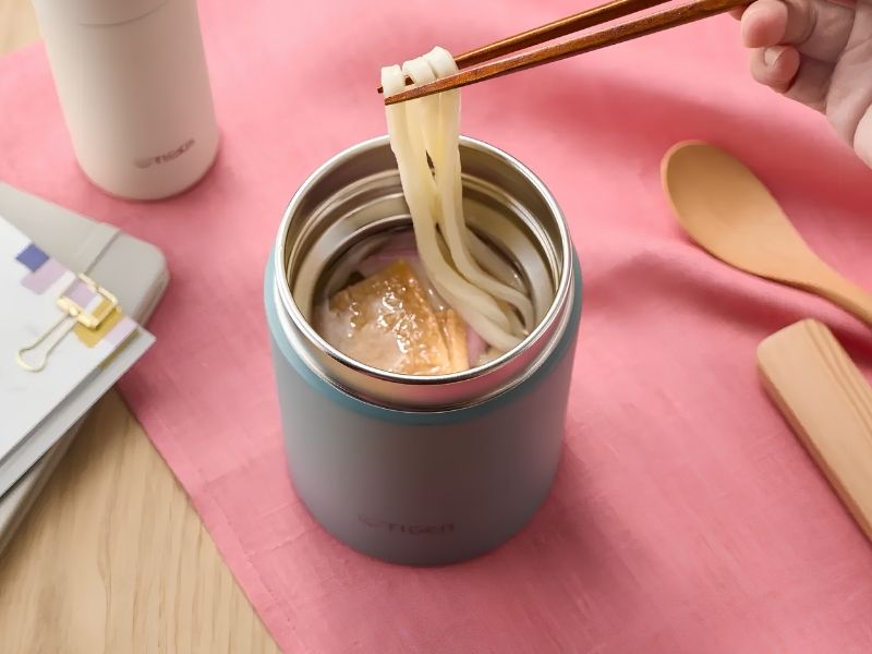 Bình giữ nhiệt đựng mì và thức ăn nóng, minh họa cách sử dụng bình để mang theo bữa ăn.